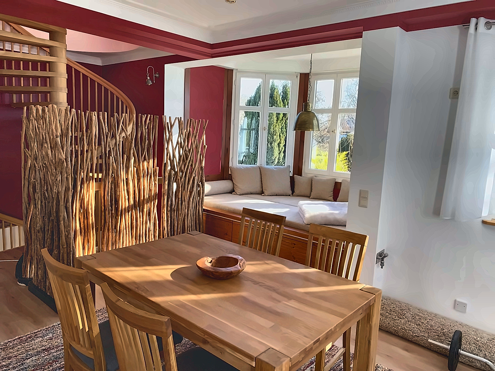 Esszimmer im Erker mit Eichentisch, Treibholz-Raumteiler und Wendeltreppe