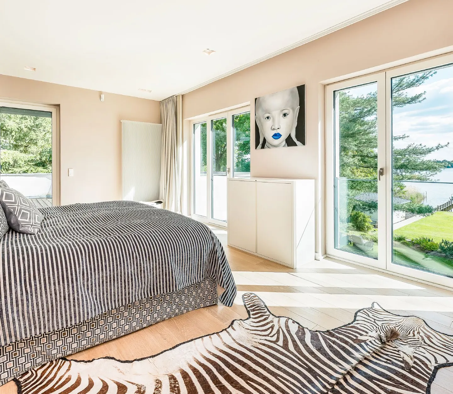 Masterschlafzimmer mit Fensterfront und Seeblick