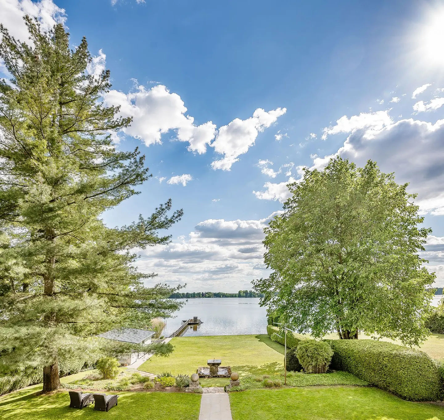 Blick über den Garten auf den Teupitzer See mit Steg und Bootshaus