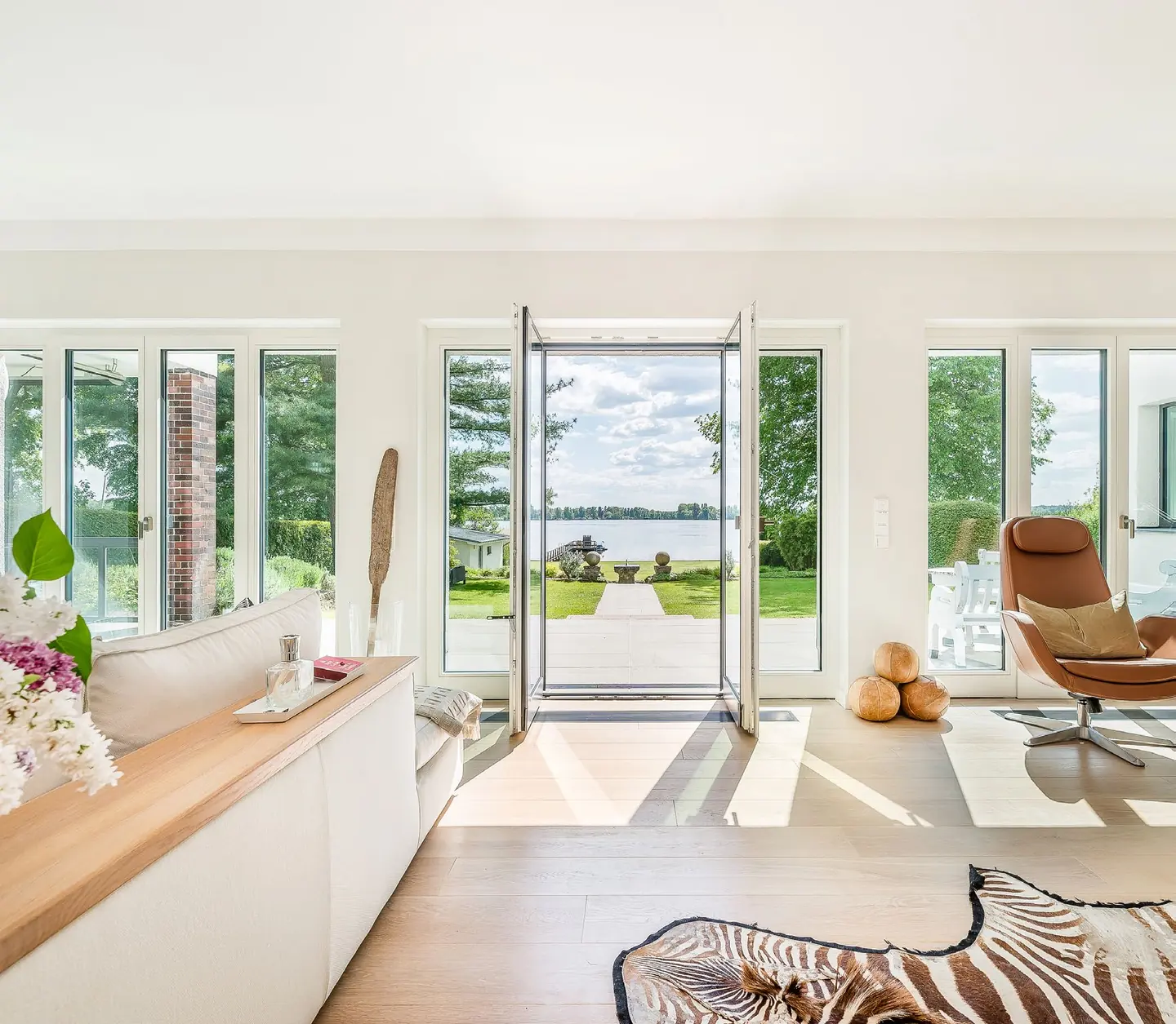 Wohnbereich mit geöffneter Fenstertür und Blick auf den Teupitzer See
