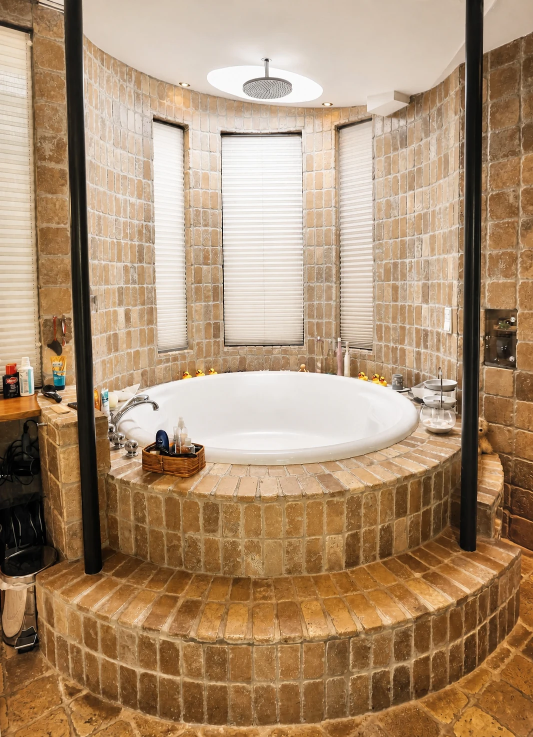 Runde, in Naturstein gefliesste Badewanne auf einem Podest mit drei schmalen Fenstern